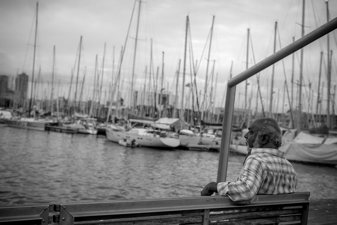Скучающий мужчина с философским видом на скамейке любуется чайками, "захватившими" порт Барселоны:)