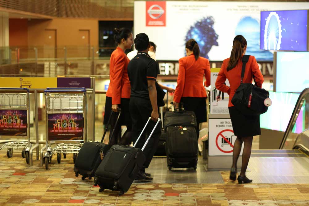 Представители малайской авиакомпании Jet Star на фоне входа в Терминал 1 (зона прибытия)
