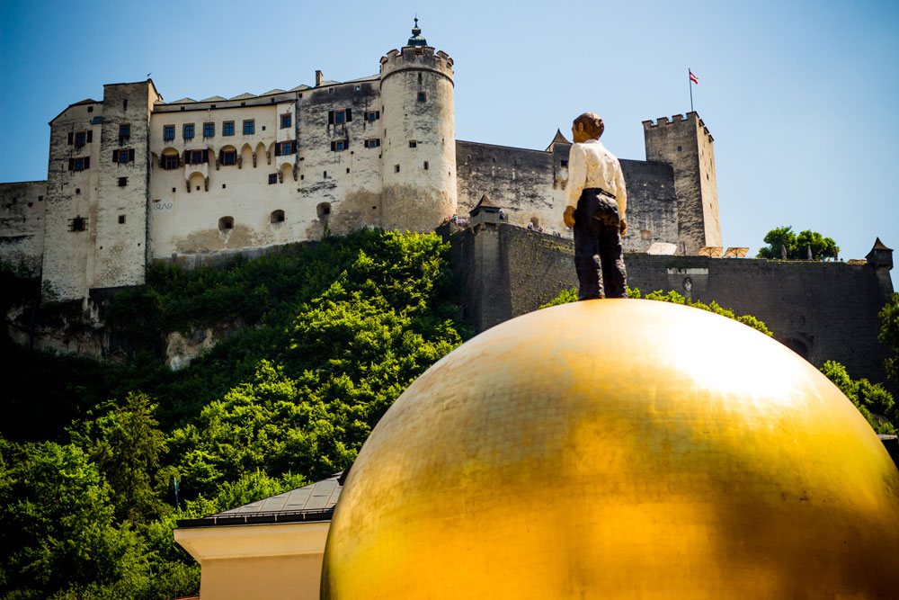 Одна из самых больших крепостей в Европе - Хоэнзальцбург. На переднем плане арт-инсталляция "Человек на шаре". На самом деле это памятник Паулю Фюрсту