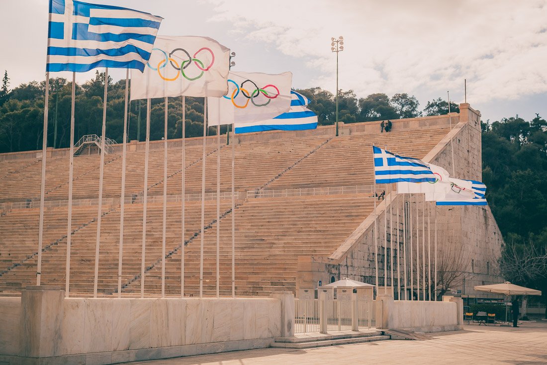 Олимпийские и греческие флаги у входа на стадион