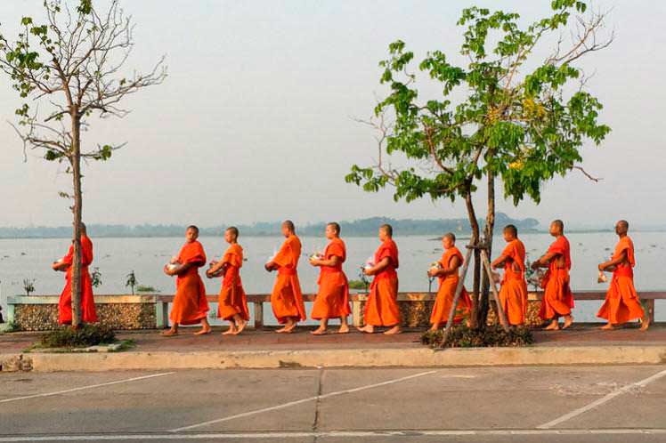 Буддистские монахи собирают милостыню на улице г. Пхаяу