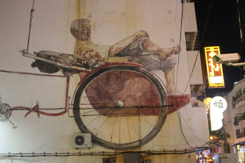 Этот стрит-арт во всю стену здания называется "Trishaw Man". Это местные рикши на велосипедах.