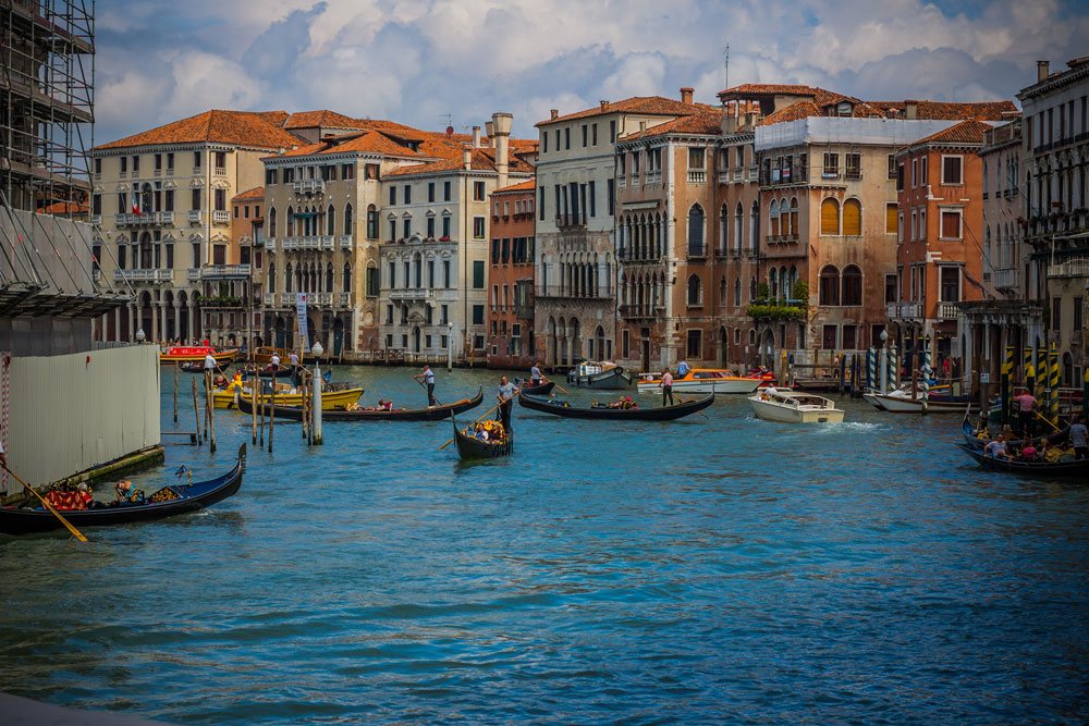 Гранд Канал в Венеции, гондольеры и лодки в едином движении
