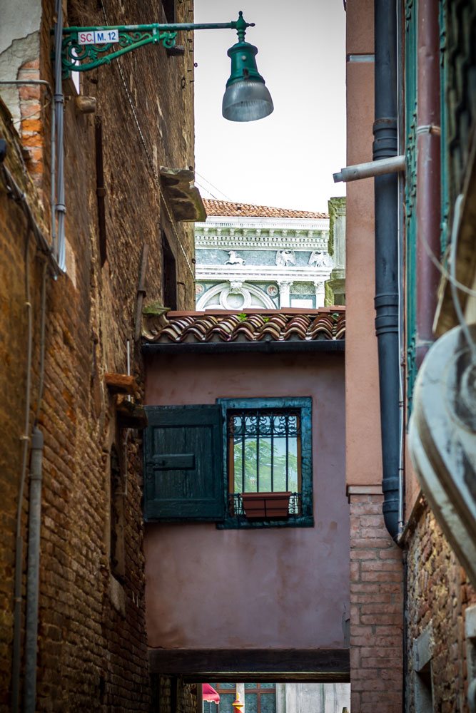 Переход-коридор между домами в Венеции, окошко и черепица, одинокий фонарь в догонку.