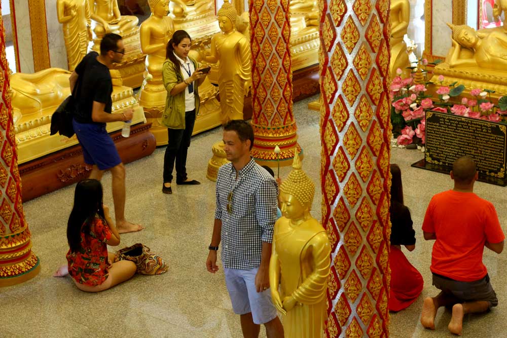 Кто-то фотографируется на фоне Будды, кто-то молится, причем некоторые европейцы тоже